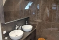 Badkamer met ligbad en grijs tinten